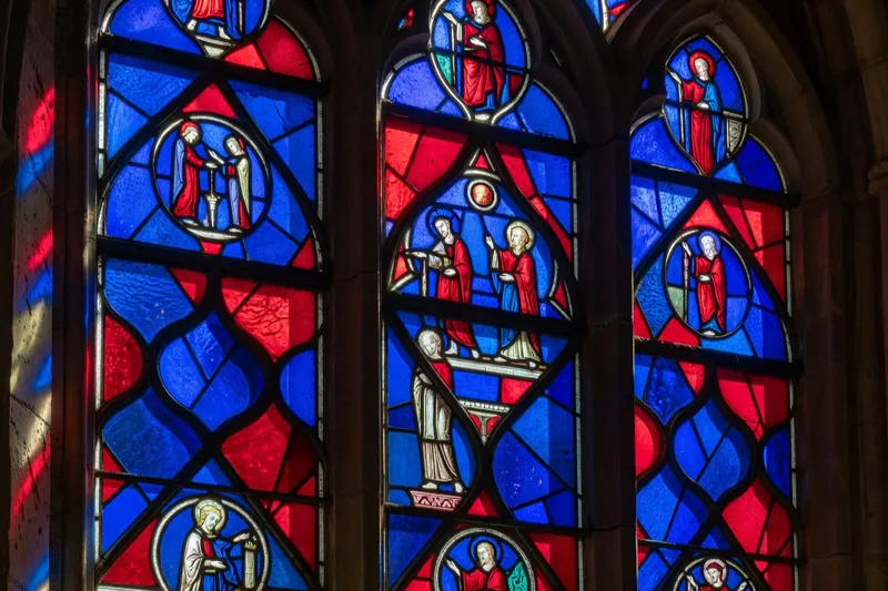 Vitrail bleu de Chartres en détail, lumière traversant les verres médiévaux du XIIIᵉ siècle